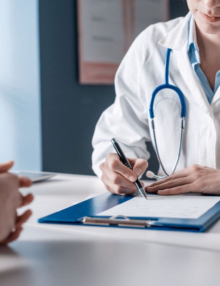 Doctor reviewing forms with a patient during healthcare intake