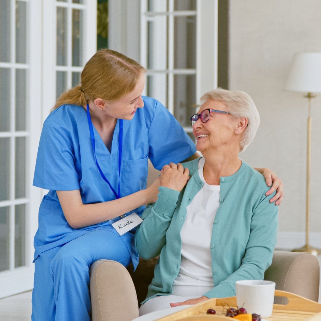 Healthcare worker reassuring an elderly patient at home